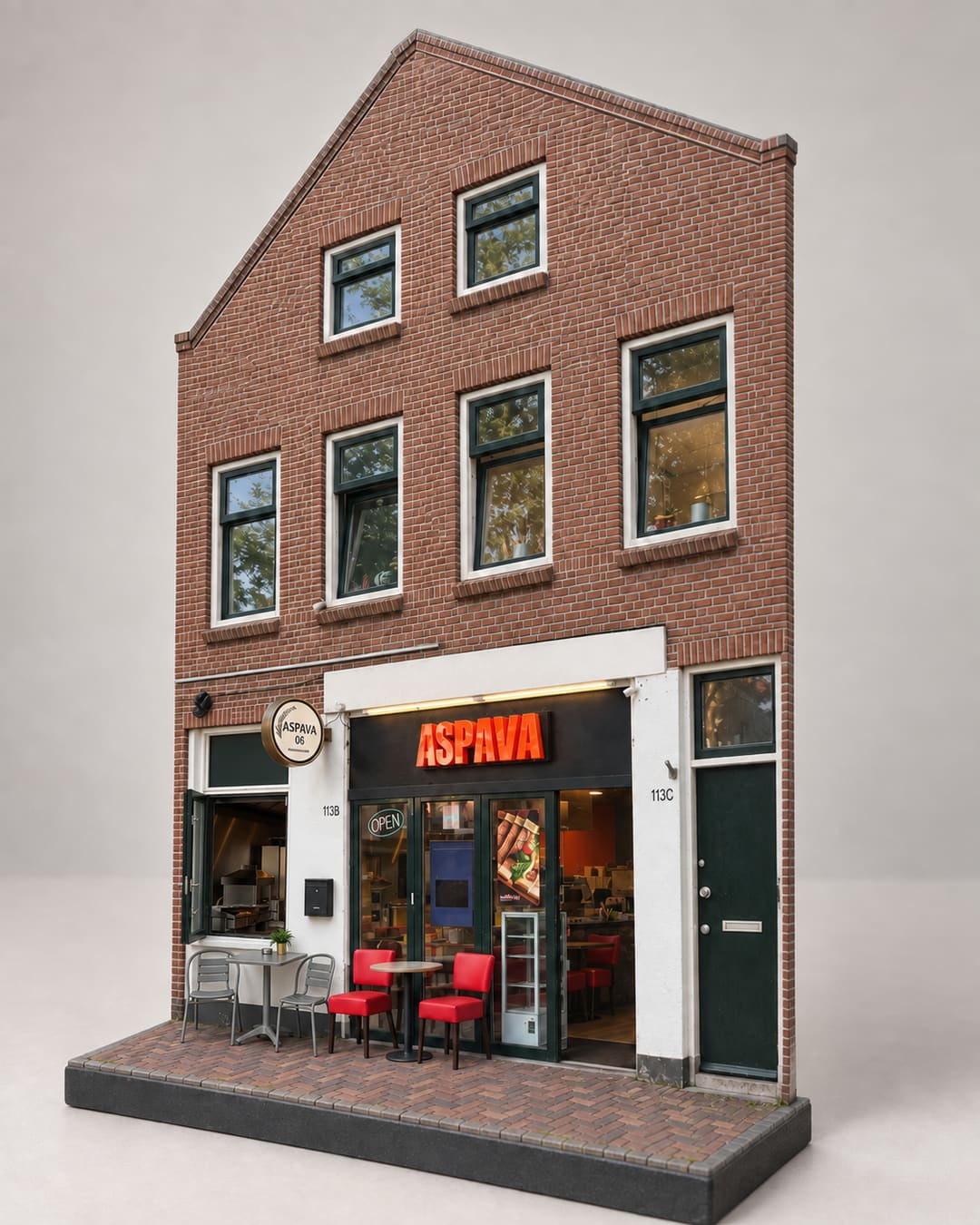 Bakstenen pand met puntgevel, oranje ASPAVA-letters boven de etalage en rode stoelen op de stoep